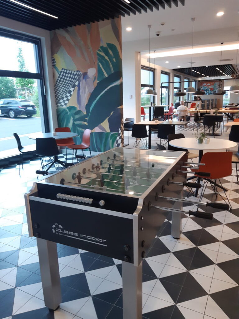 Gemeinschaftsbereich im Hotel mit Kickertisch und buntem Wandbild