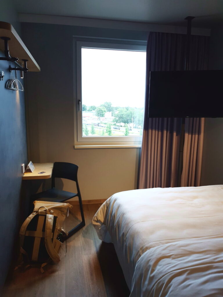 Modern eingerichtetes Hotelzimmer mit Bett und Fenster