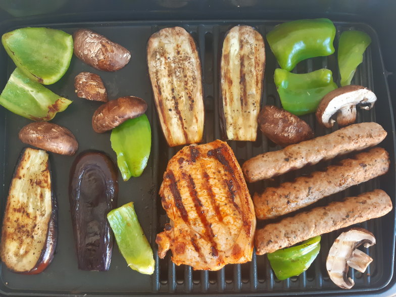Gegrilltes Gemüse, Würstchen und Fleisch auf dem Grillrost