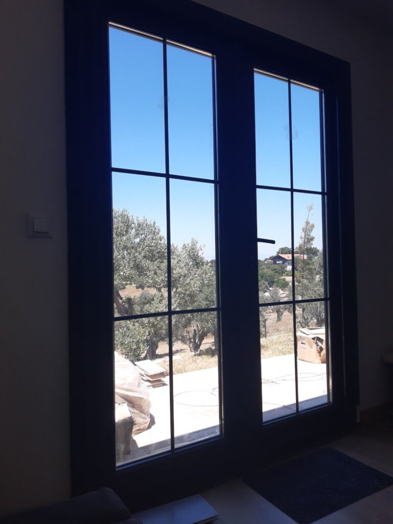 Blick von innen durch die Fenstertür auf die im Bau befindliche Terrasse des Tiny House