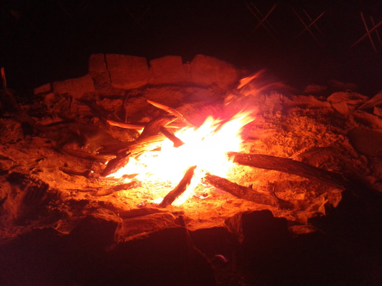 Glühendes Lagerfeuer bei Nacht am Campingplatz nahe dem Uluru